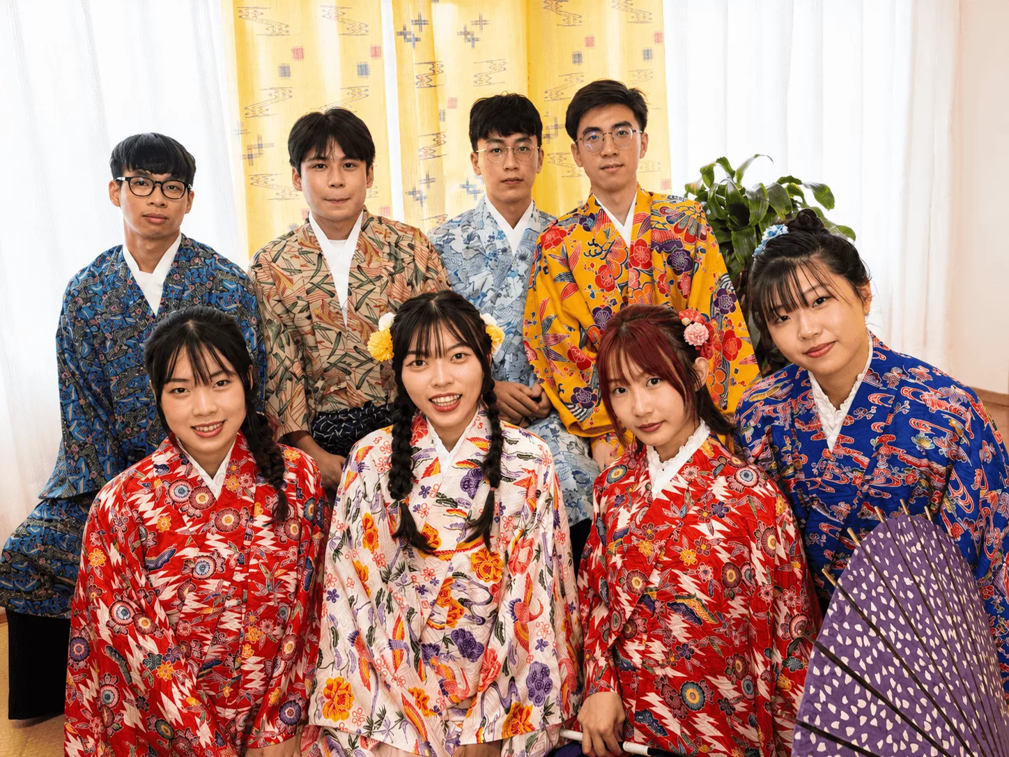 様々な色合いの琉装を着用して集合撮影をするグループ写真