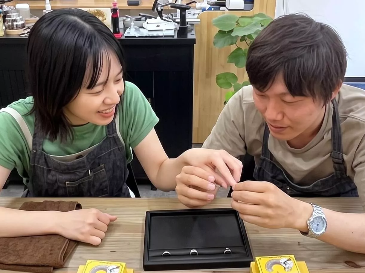 ケースに入った手作りペアシルバーリングの完成作品を見つめるカップル（和歌山・みなべ町）